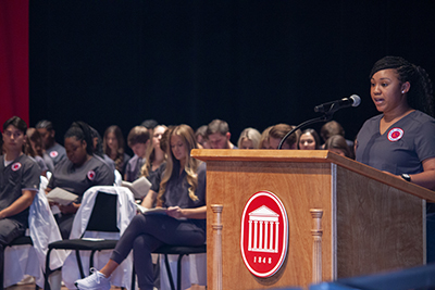 nursing student speaking from a podium during a white coat ceremony