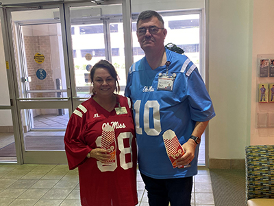 photo of two people enjoying their popcorn wearing football jerseys