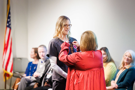 photo of nursing student receiving their nursing pin at the graduating Pinning ceremony