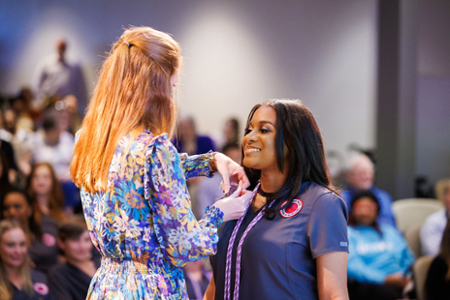 photo of nursing student receiving their nursing pin at the graduating Pinning ceremony