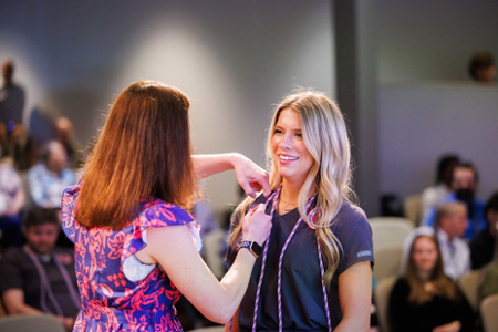 photo of nursing student receiving their nursing pin at the graduating Pinning ceremony