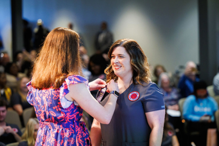 photo of nursing student receiving their nursing pin at the graduating Pinning ceremony