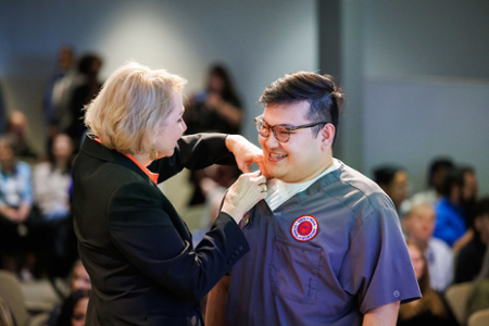 photo of nursing student receiving their nursing pin at the graduating Pinning ceremony