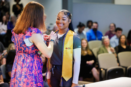 photo of nursing student receiving their nursing pin at the graduating Pinning ceremony